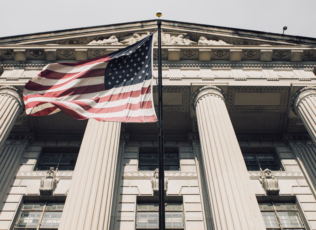 American flag flying at the entrance of a government building